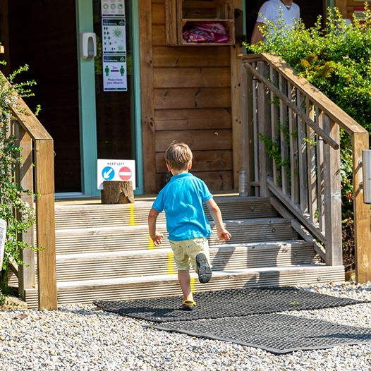 child running up steps at Baxby Manor Campsite