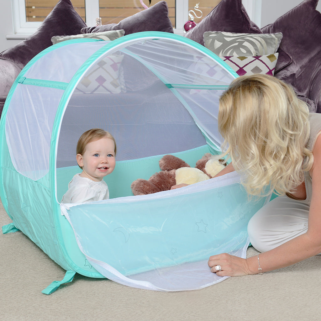 Baby in Pop-Up Travel Bubble Cot for camping babies, at Kids Camping Store, next to Mum