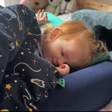 Load image into Gallery viewer, A small child asleep in her Bundle Bed at a sleepover, next to the bumper.
